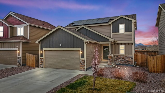 9840 Castor Dr, Colorado Springs, CO 80925 - craftsman inspired home featuring stone siding, concrete driveway, a garage, and fence