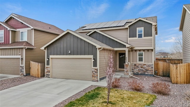 9840 Castor Dr, Colorado Springs, CO 80925 - craftsman house with stone siding, a garage, fence, and solar panels