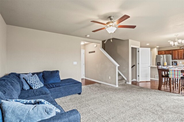 9840 Castor Dr, Colorado Springs, CO 80925 - living area with baseboards, stairway, ceiling fan with notable chandelier, and dark colored carpet