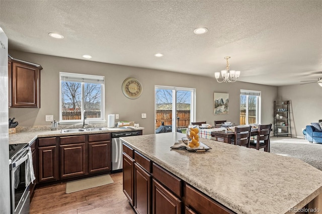 9840 Castor Dr, Colorado Springs, CO 80925 - kitchen featuring open floor plan, light countertops, stainless steel appliances, a sink, and light wood-style floors
