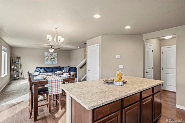9840 Castor Dr, Colorado Springs, CO 80925 - kitchen featuring dark wood-type flooring, light countertops, an inviting chandelier, and a center island