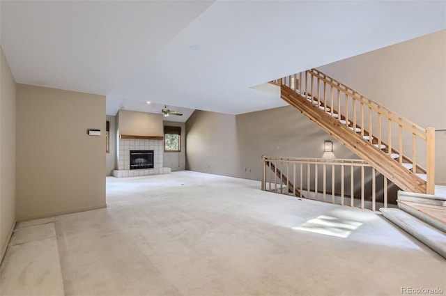 unfurnished living room with carpet, ceiling fan, and a tile fireplace