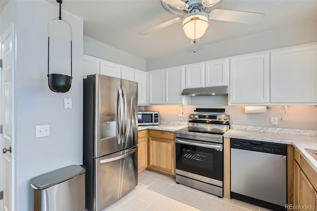 8136 Washington St Unit 141, Denver, CO 80229 - kitchen featuring stainless steel appliances, under cabinet range hood, ceiling fan, light tile patterned floors, and white cabinets
