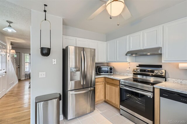 8136 Washington St Unit 141, Denver, CO 80229 - kitchen featuring stainless steel appliances, under cabinet range hood, ceiling fan, white cabinets, and baseboards