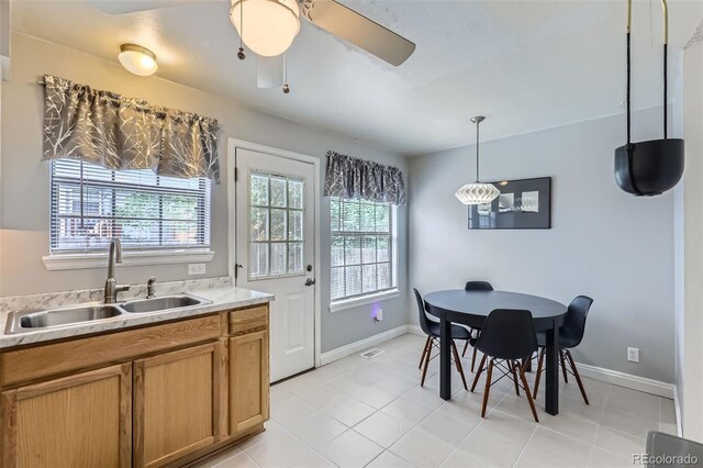 8136 Washington St Unit 141, Denver, CO 80229 - kitchen with a sink, light countertops, light tile patterned flooring, a ceiling fan, and baseboards