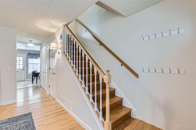 8136 Washington St Unit 141, Denver, CO 80229 - stairway with a textured ceiling, wood finished floors, and baseboards