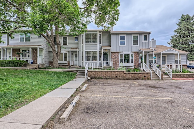 8136 Washington St Unit 141, Denver, CO 80229 - multi unit property featuring covered porch, brick siding, board and batten siding, and a front lawn