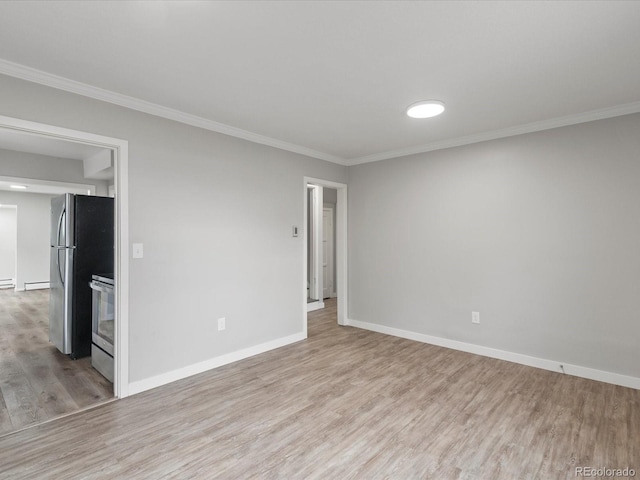 spare room featuring light hardwood / wood-style flooring and ornamental molding