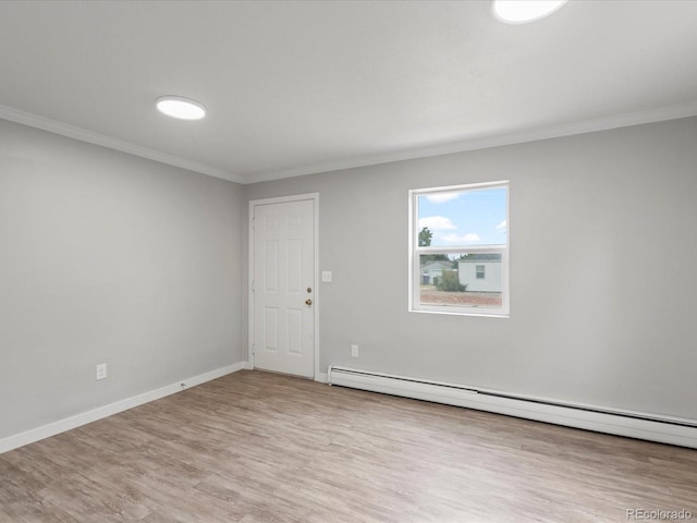 unfurnished room with crown molding, a baseboard heating unit, and hardwood / wood-style flooring