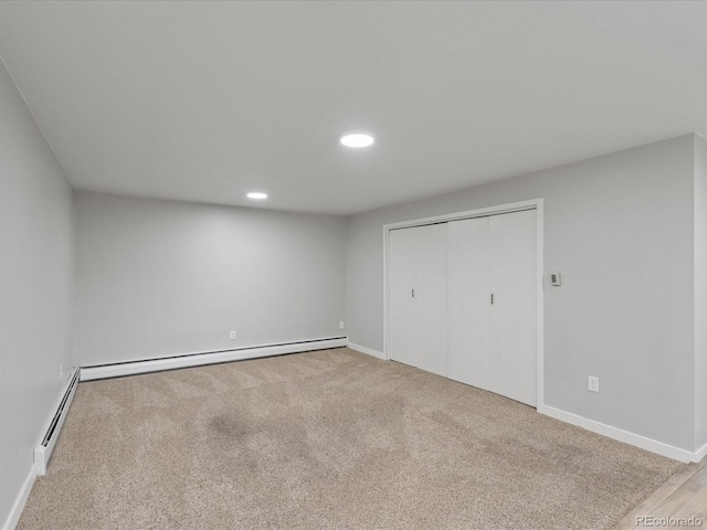 spare room featuring light colored carpet and baseboard heating