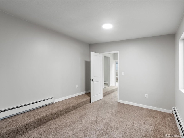 carpeted empty room featuring baseboard heating