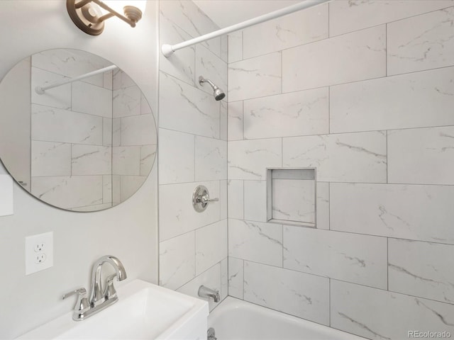 bathroom with sink and tiled shower / bath