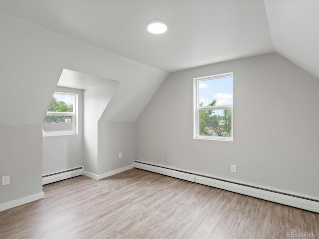 bonus room featuring light wood-type flooring, vaulted ceiling, and a baseboard radiator