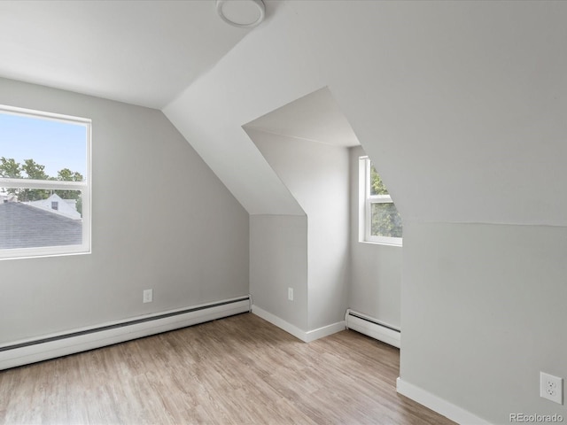 additional living space featuring lofted ceiling, a baseboard heating unit, and hardwood / wood-style floors