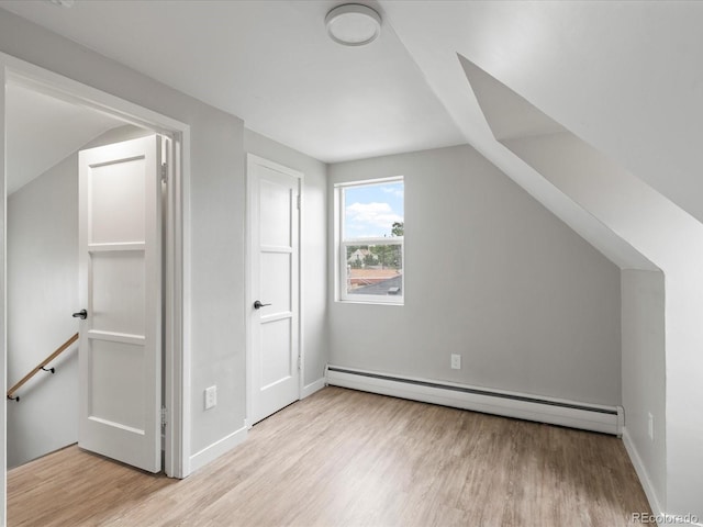 bonus room featuring a baseboard radiator, light hardwood / wood-style floors, and lofted ceiling