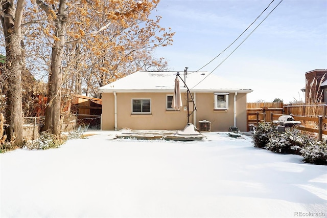 snow covered house with central AC