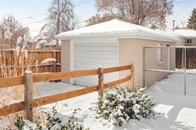 snow covered structure featuring a garage