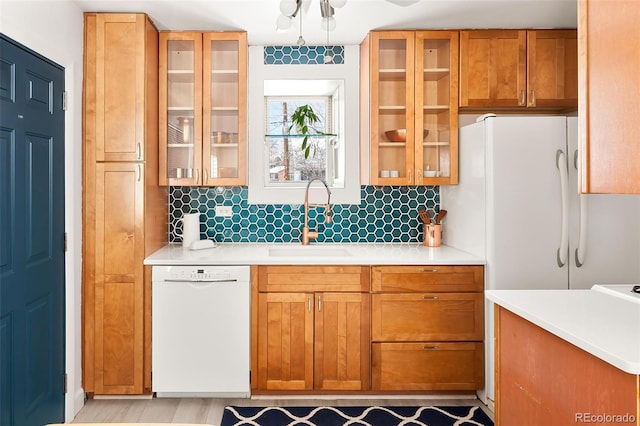 kitchen featuring sink, white appliances, and decorative backsplash