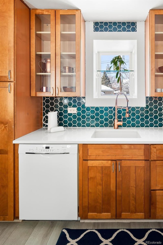 kitchen featuring white dishwasher, sink, and backsplash