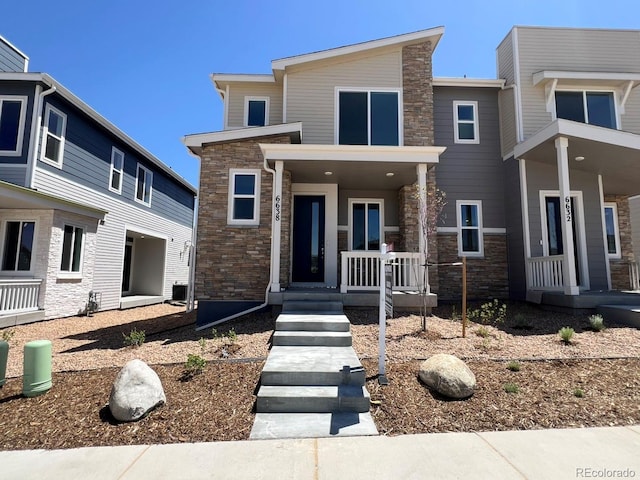 6638 N Nepal Ct, Aurora, CO 80019 - view of front facade featuring stone siding and a porch