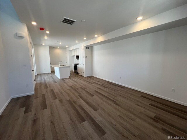 6638 N Nepal Ct, Aurora, CO 80019 - unfurnished living room with a sink, recessed lighting, baseboards, and dark wood-type flooring
