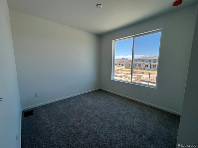 6638 N Nepal Ct, Aurora, CO 80019 - spare room featuring dark carpet and baseboards