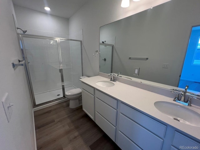 6638 N Nepal Ct, Aurora, CO 80019 - bathroom with wood finished floors, a stall shower, toilet, and double vanity