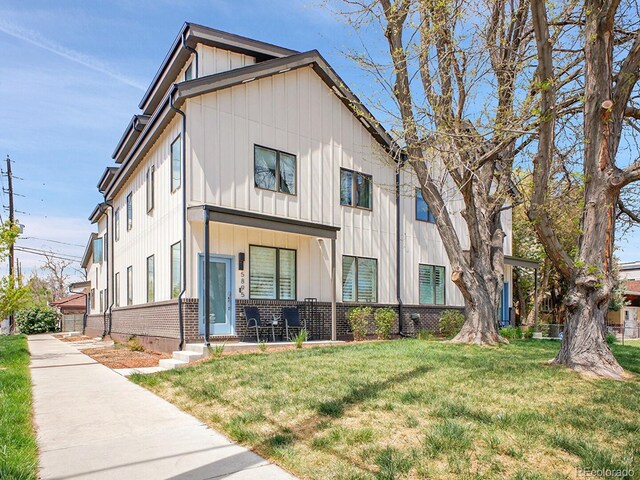1303 Jersey St, Denver, CO 80220 - view of front of property featuring board and batten siding, a front yard, and brick siding