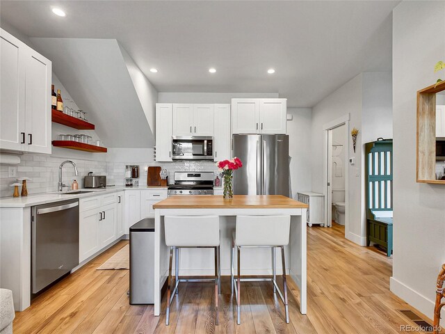 1303 Jersey St, Denver, CO 80220 - kitchen featuring stainless steel appliances, backsplash, open shelves, white cabinets, and a sink