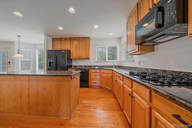 kitchen featuring black appliances, light wood-style floors, and recessed lighting