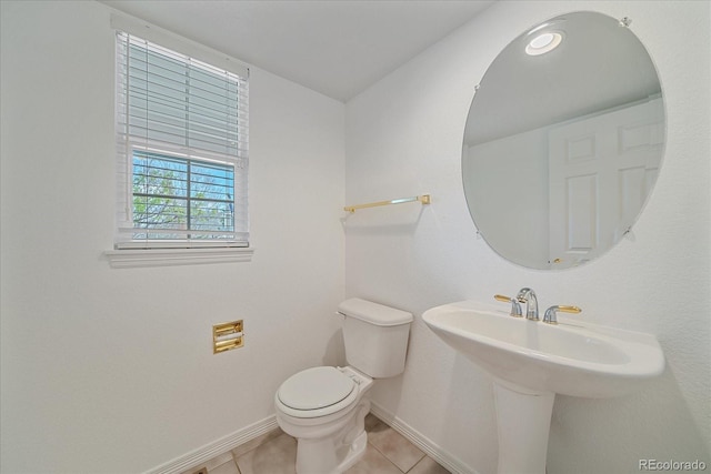 bathroom with tile patterned flooring, toilet, and baseboards