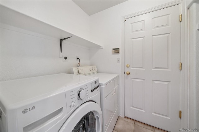 laundry room featuring light tile patterned flooring, laundry area, and washing machine and dryer