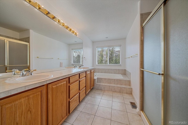 full bathroom with a bath, tile patterned flooring, a shower stall, and a sink