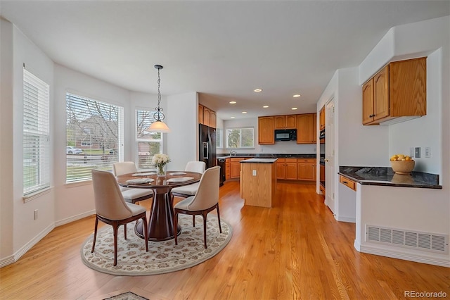 dining room with light wood-style flooring, baseboards, and recessed lighting