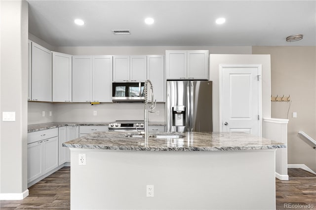 847 E 98th Ave Unit 1806, Thornton, CO 80229 - kitchen featuring stainless steel appliances, dark wood-style flooring, light stone counters, baseboards, and a center island with sink