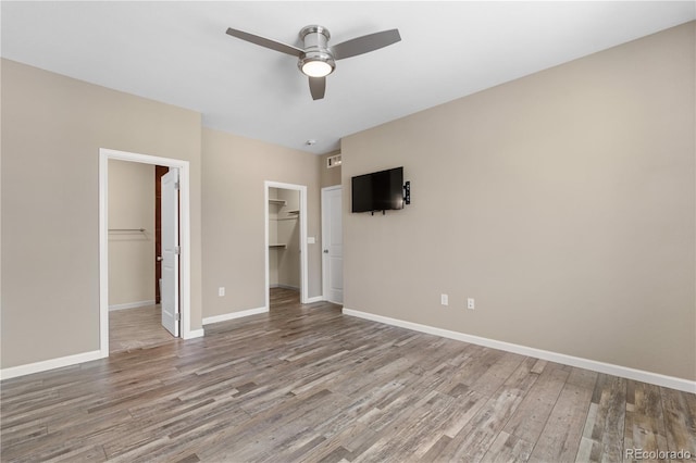 847 E 98th Ave Unit 1806, Thornton, CO 80229 - unfurnished bedroom with a spacious closet, wood finished floors, a closet, and baseboards