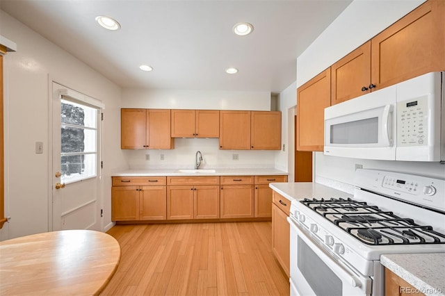 kitchen featuring sink, white appliances, and light hardwood / wood-style flooring