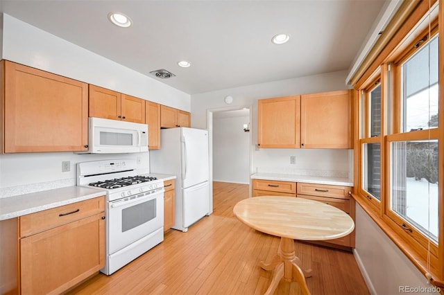 kitchen with white appliances and light hardwood / wood-style floors