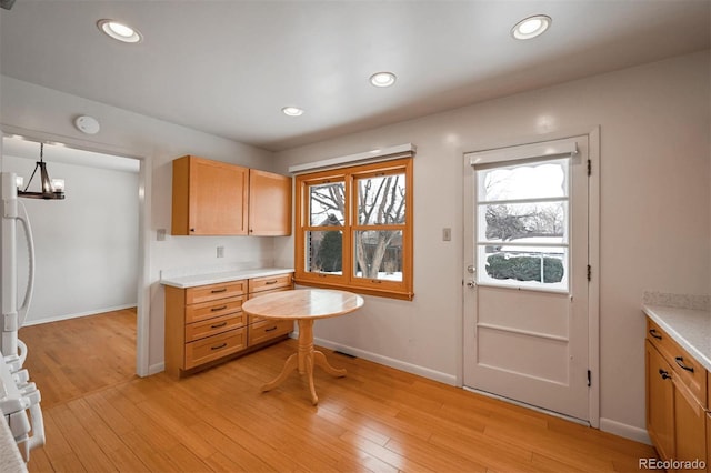 kitchen featuring pendant lighting, a notable chandelier, and light wood-type flooring