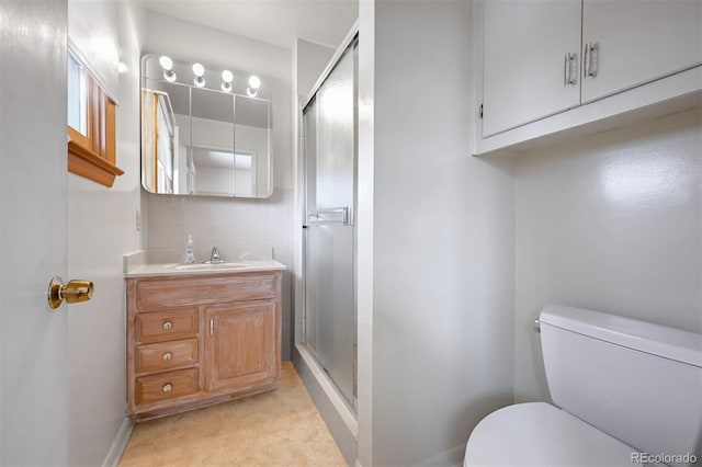 bathroom with an enclosed shower, vanity, backsplash, and toilet