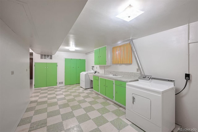 washroom with independent washer and dryer, sink, and cabinets