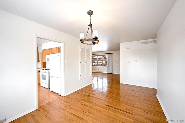 interior space with a notable chandelier and light wood-type flooring