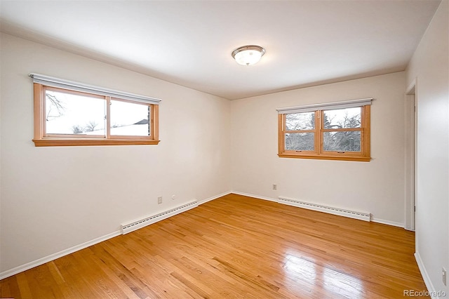 spare room with plenty of natural light, light wood-type flooring, and baseboard heating