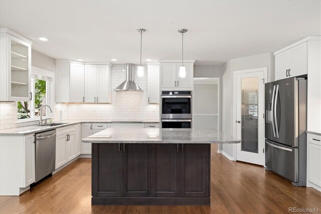 3901 Stonegrass Pt, Broomfield, CO 80023 - kitchen featuring appliances with stainless steel finishes, wall chimney exhaust hood, dark wood-style flooring, a center island, and recessed lighting