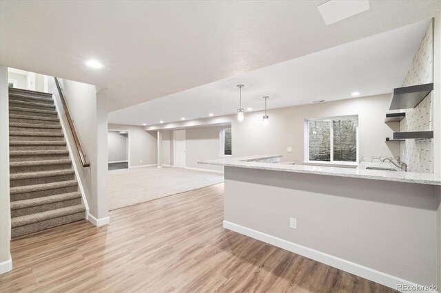 3901 Stonegrass Pt, Broomfield, CO 80023 - kitchen with open shelves, recessed lighting, a peninsula, light wood-style flooring, and light stone countertops