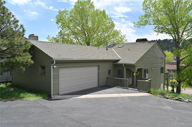 23846 Genesee Village Rd, Golden, CO 80401 - view of front of home with a chimney, driveway, an attached garage, and roof with shingles