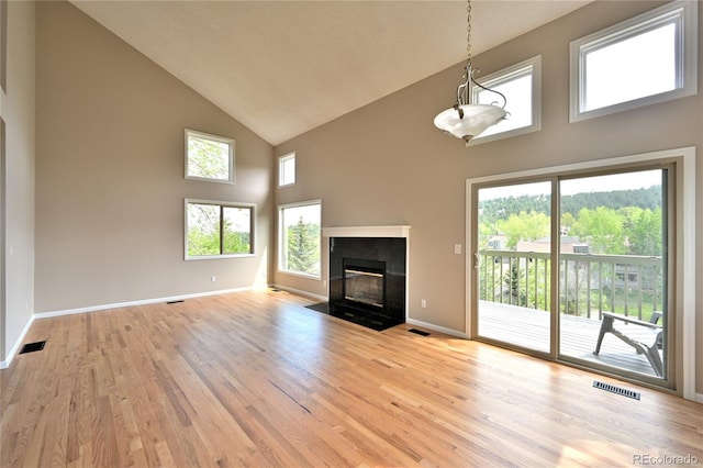 23846 Genesee Village Rd, Golden, CO 80401 - unfurnished living room featuring high vaulted ceiling, light wood-style flooring, baseboards, and a fireplace with flush hearth