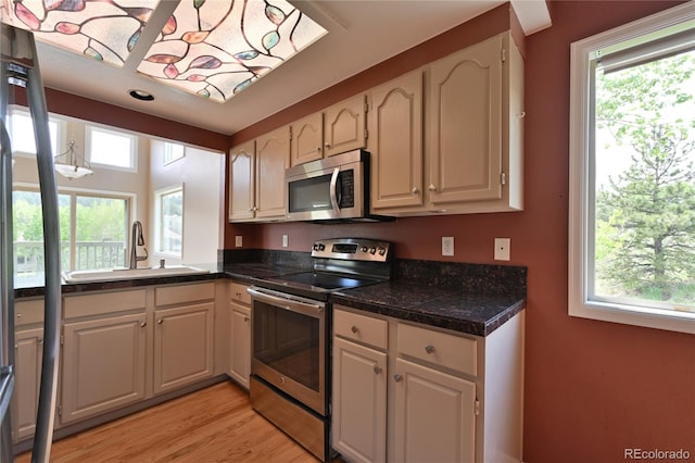 23846 Genesee Village Rd, Golden, CO 80401 - kitchen featuring appliances with stainless steel finishes, a sink, tile counters, and light wood finished floors