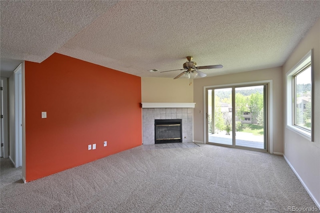 23846 Genesee Village Rd, Golden, CO 80401 - unfurnished living room with carpet, ceiling fan, a tiled fireplace, and a textured ceiling