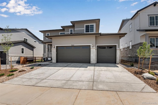 view of front of house with a garage, driveway, and fence